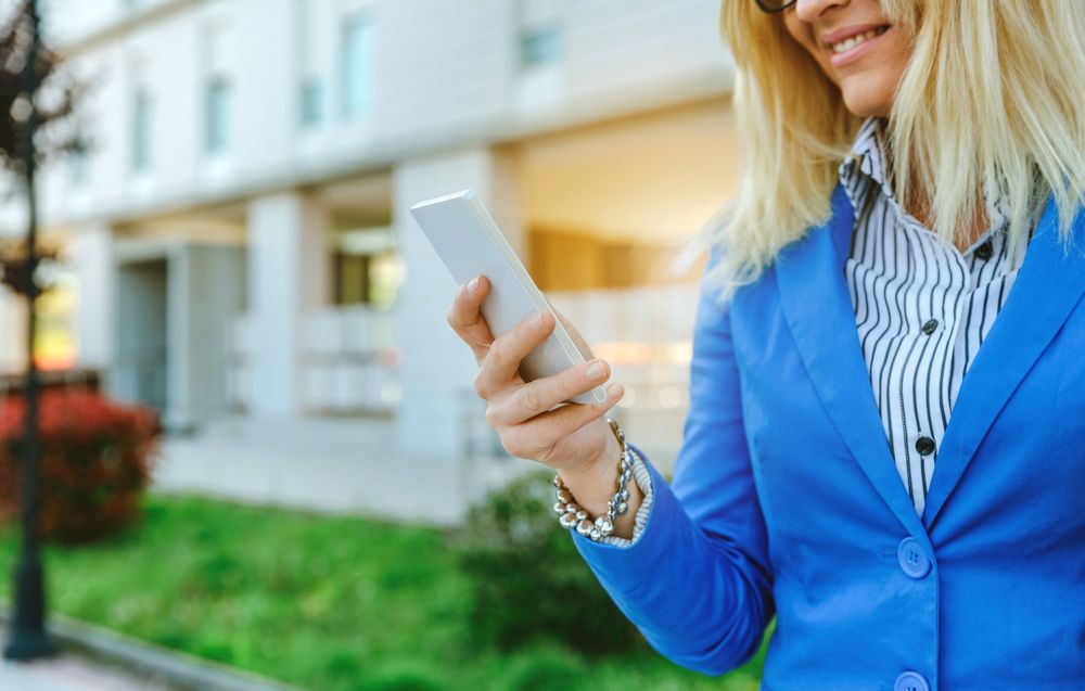 Businesswoman using mobile in the street