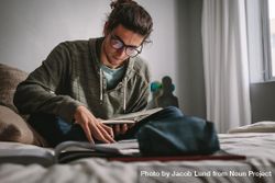 Student sitting on a bed and studying with focus and concentration 5Ry1N0