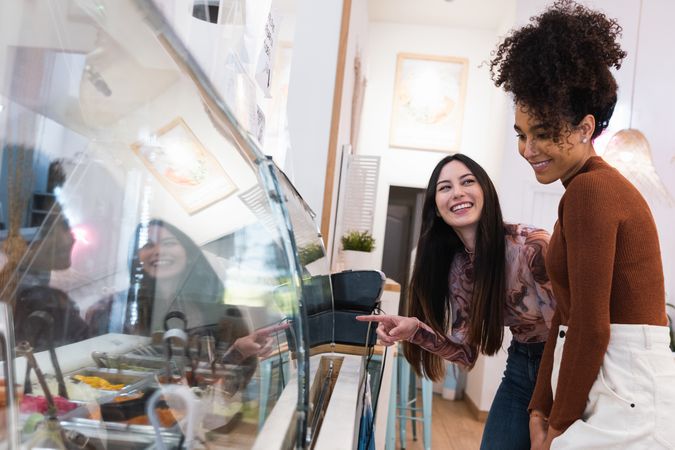 Multiethnic women choosing food in restaurant