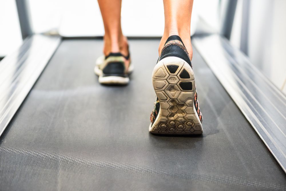 Ankles of male on running machine