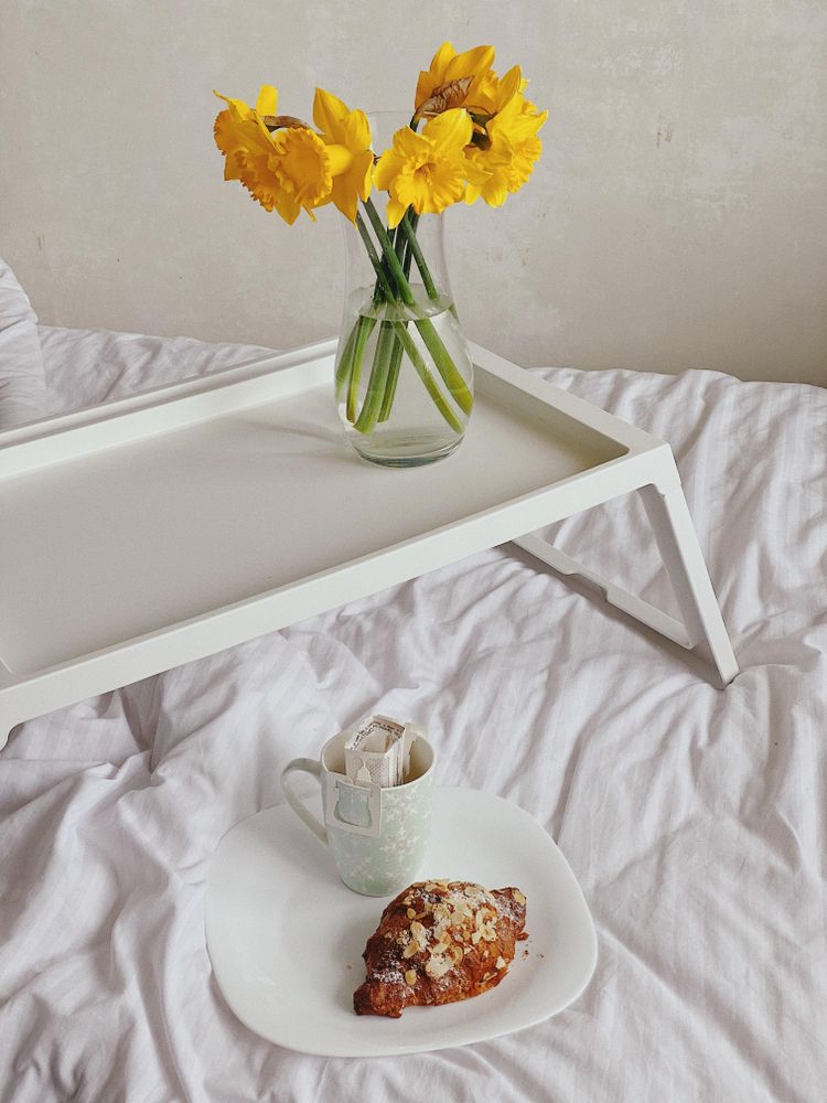 Plate with croissant on bed