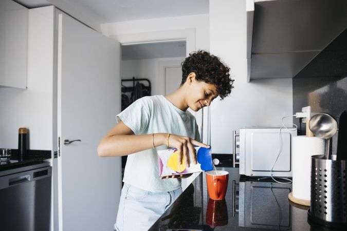 Girl preaparing a cup of milk