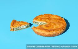 Phyllo dough savory pie with spinach and cheese, isolated on a blue background 4OQ6R0