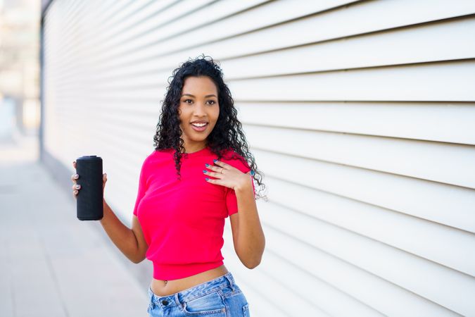 A Confident Woman Posing with a Drink in Hand Against a Stylish Modern Background Setting