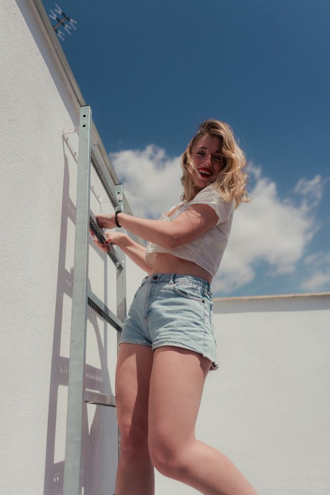 Female hipster in stylish casual clothing on stairs at roof