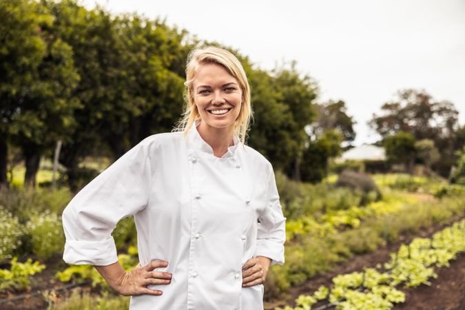 Chef standing in organic garden with her hands on her hips