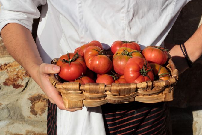 Shiny ripe tomatoes in brown wicker basket