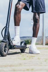 Black man riding on electric scooter in park