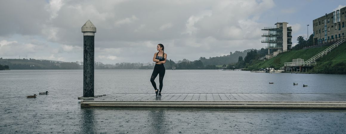 Sportswoman looking lake from pier