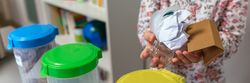 Girl in ecology classroom showing handful of waste to recycle