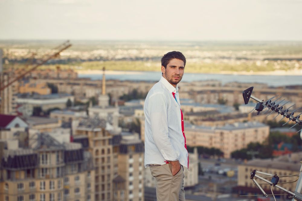 Man stands on roof and looks back at camera