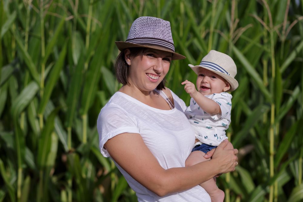 Adorable mother and child on hand enjoying and laughing in field