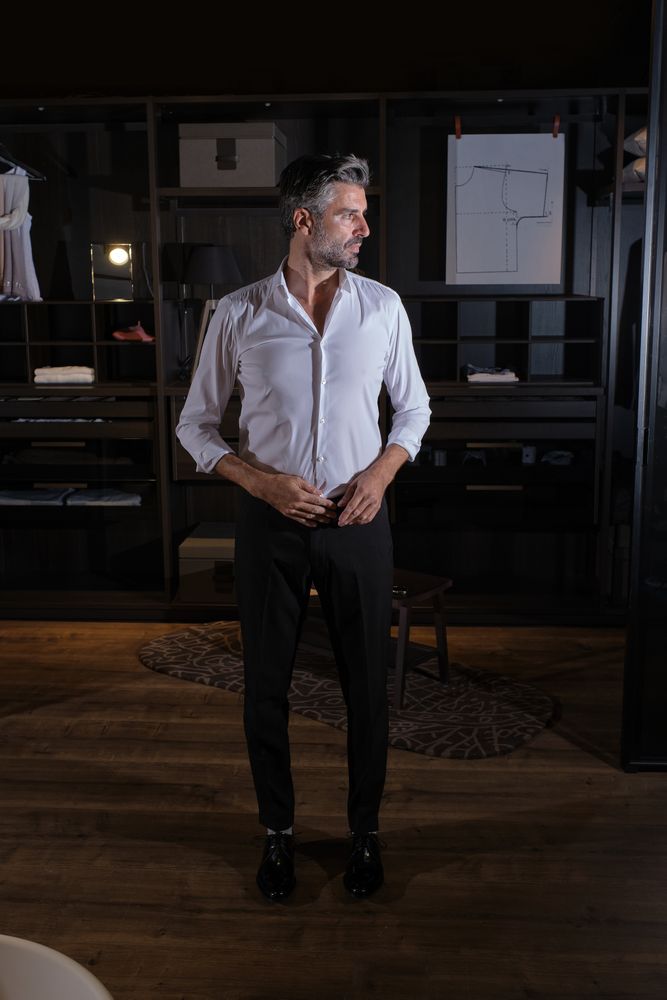 Confident unshaven man in stylish clothes in room