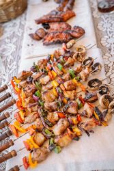 top view of plate with skewers sticks of pork with vegetables and chorizo