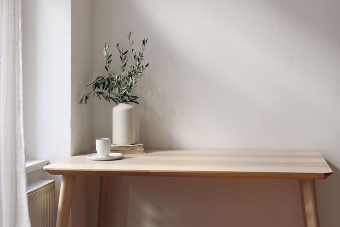 Elegant vase with olive tree branches on wooden table