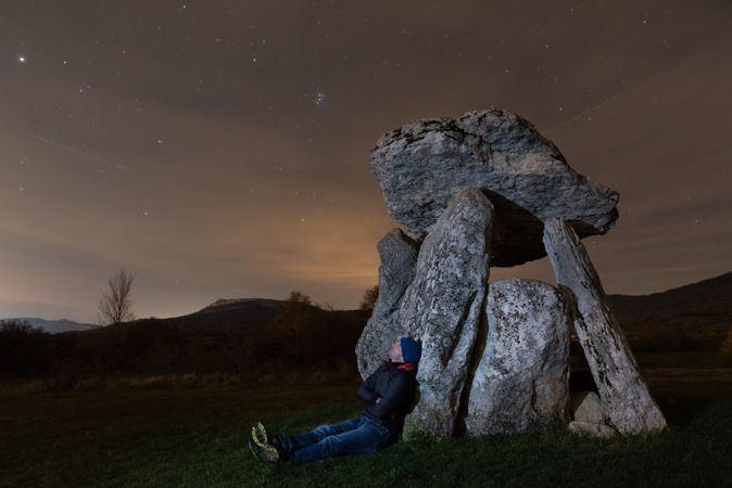Traveler admiring starry sky near dolmen