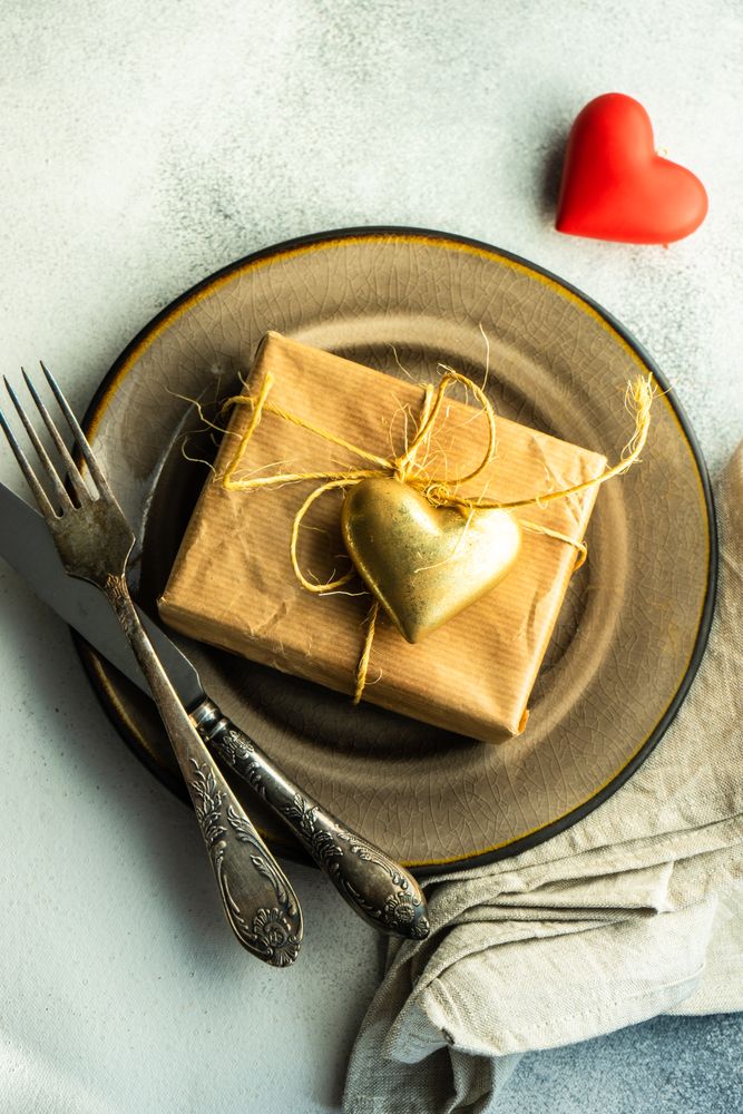 St Valentine day table setting with gift and gold & red heart