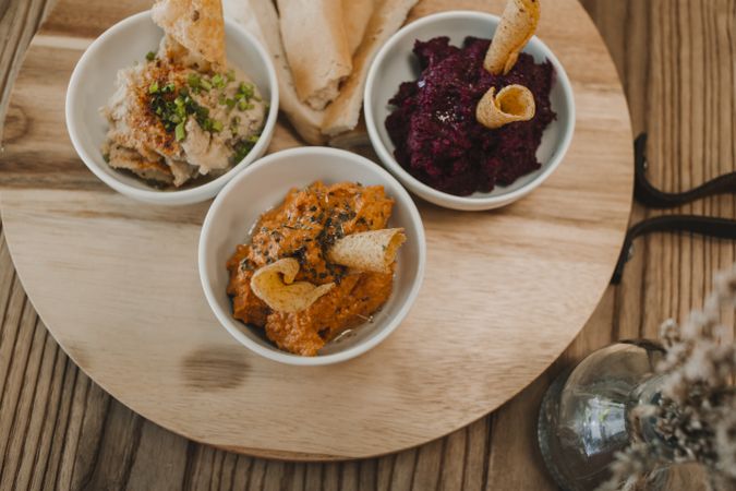 Different tasty sauces on round wooden stand