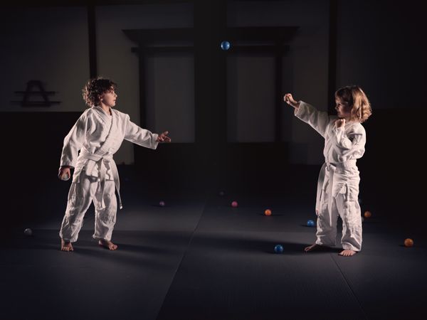 Kids practicing punches on balls during martial arts session
