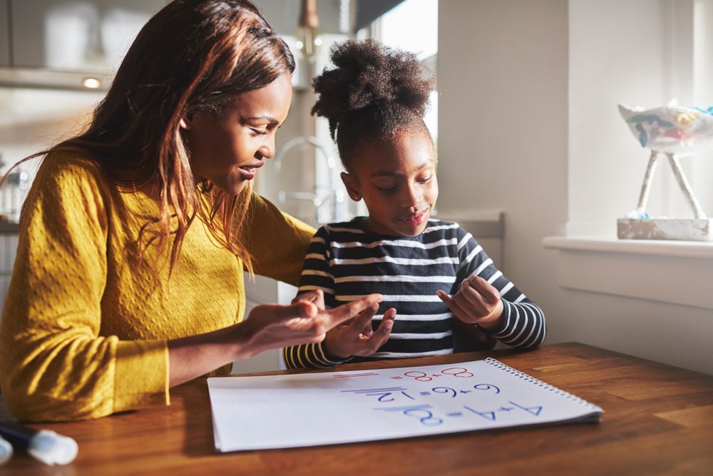 Mother helping daughter do additions using her fingers