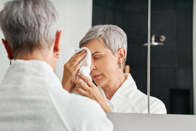 Older woman wiping face with towel