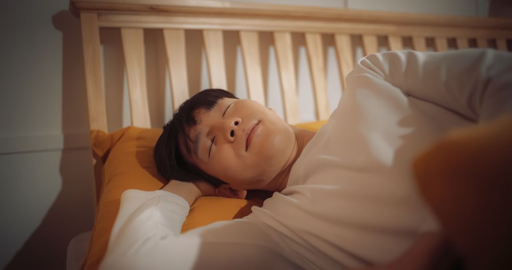 Portrait of Korean Young Man Getting Awaken by the Sun Shining Through his Window.