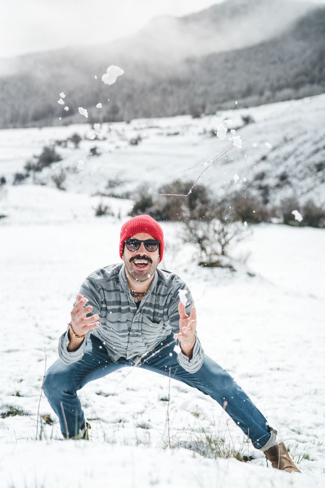 Man playing with snow on winter field