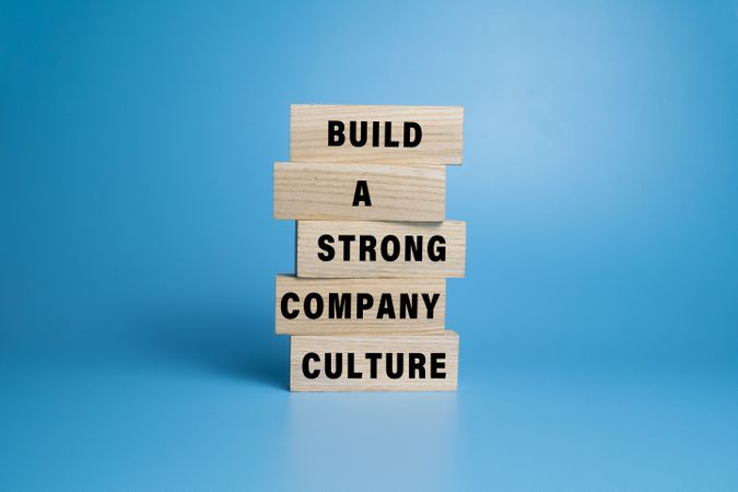 build a strong company culture words text on stack wooden blocks isolated on blue background