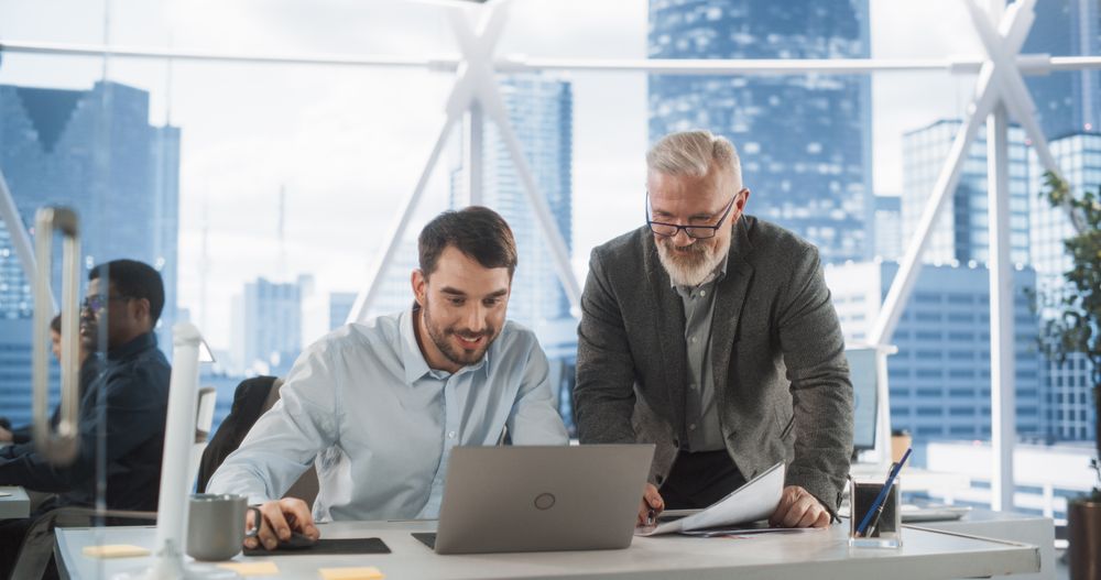Two Man Discussing Deal And Opportunities In Diverse Workspace of Investment Banking Company