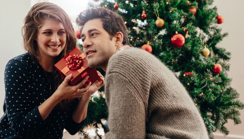 Man and woman exchanging Christmas presents at home