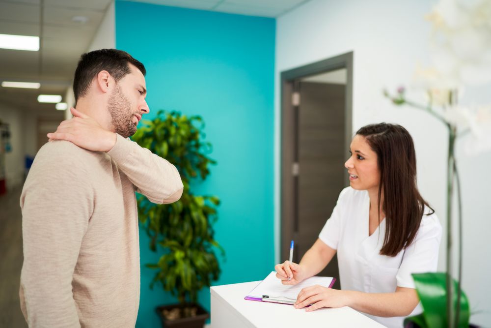 physiotherapist and patient at the clinic's reception desk