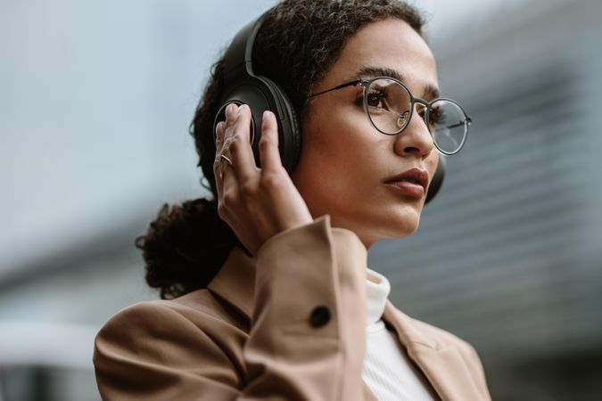 Female executive listening to music on headphones