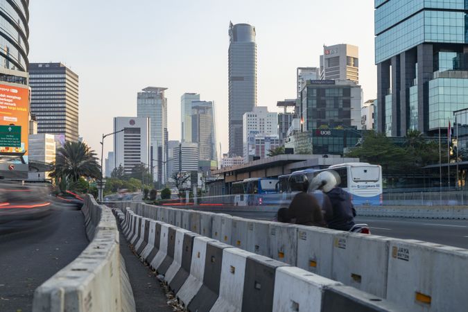 Jakarta, Indonesia - Oct 20, 2019: Skyline of skyscrapers in Jakarta, bus and motorcycle traffic