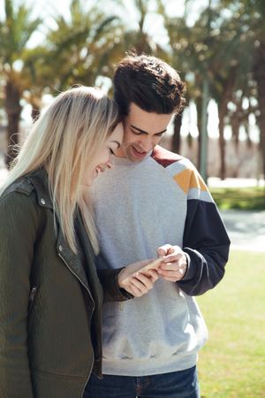 Couple using phone outdoors