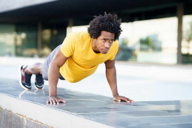 Man doing planks on cement outside