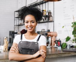 Proud woman with arms crossed at her cafe