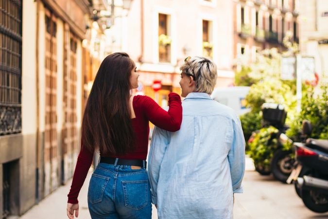back view of two women walking on a city street