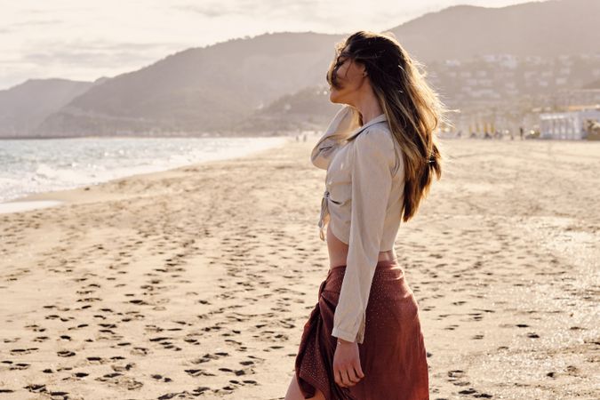 A fashion model at the beach before sunset