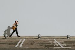 Woman with bag walking along parking lot