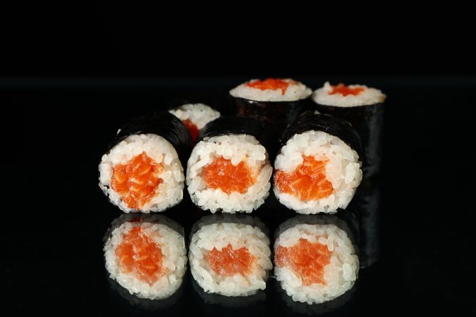 Delicious sushi rolls on dark mirror background. Japanese food