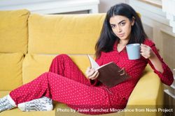 Woman relaxing in red pajamas at home with book 5omDyb
