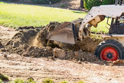 Small Bulldozer Digging In Yard For Pool Installation