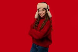 Smiling girl in red sweater and fur hat