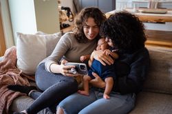 New family kissing baby on video call