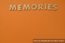 The word “Memories” written in cork on top of of dusty orange background, copy space 4jLOx0