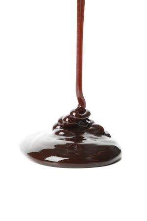 Melted chocolate is pouring, isolated on blank background