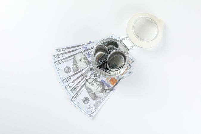 Jar with Dollar bills on light background