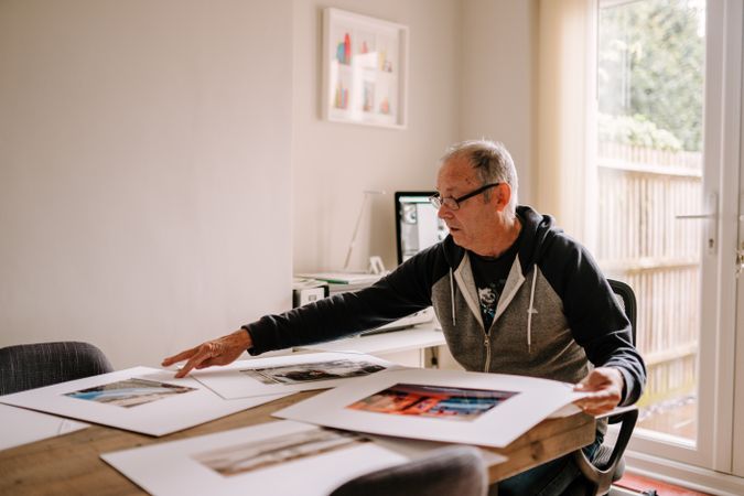 Man looking at photos in his home office