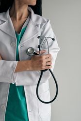 Crop confident physician with stethoscope and crossed arms