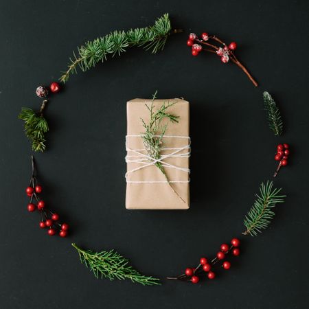 Christmas wreath and present made of winter items on dark background